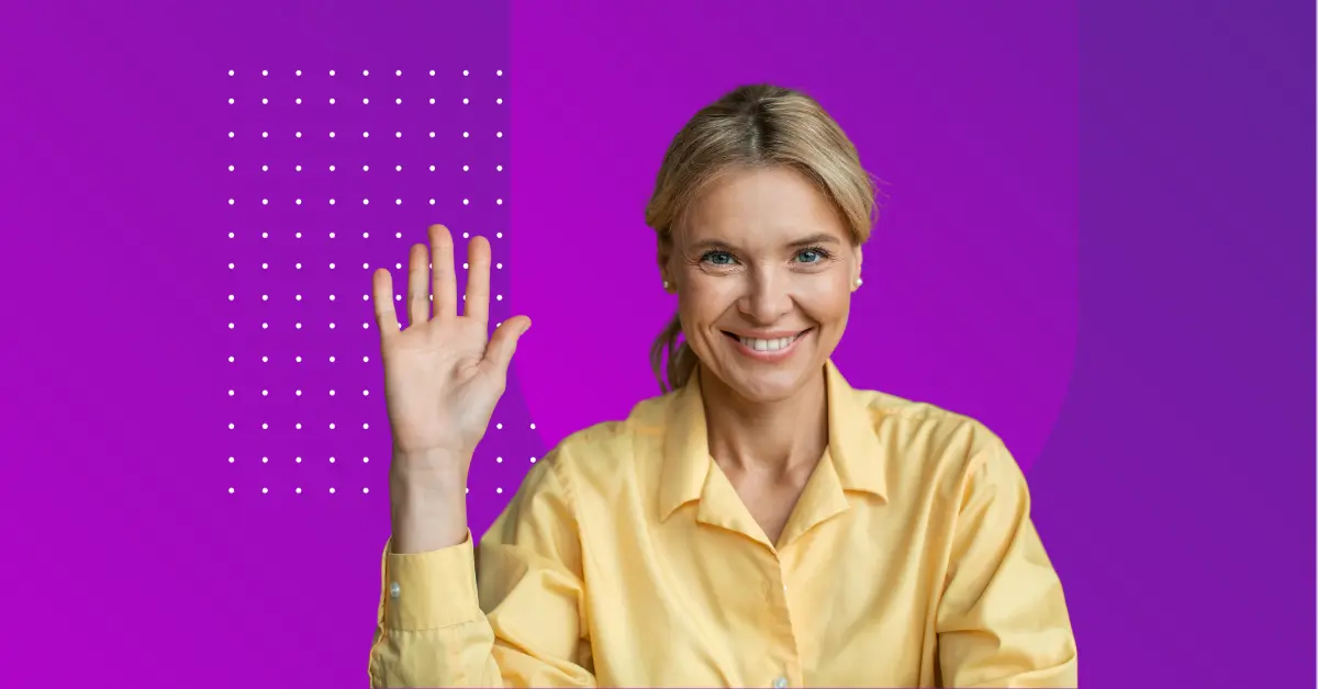Woman smiling and looking confident while raising hand.