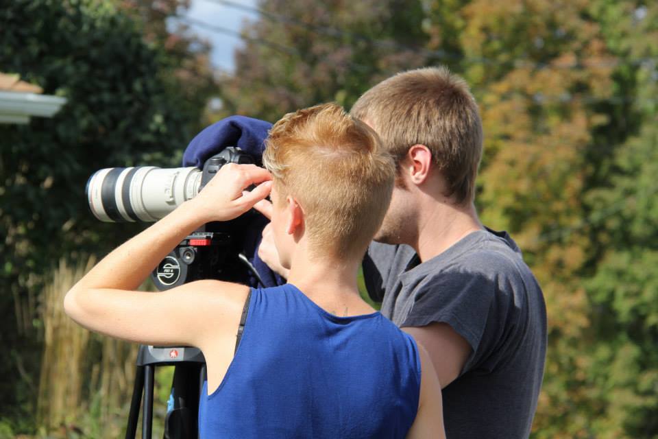 Film crew members setting up an outdoor camera shot.