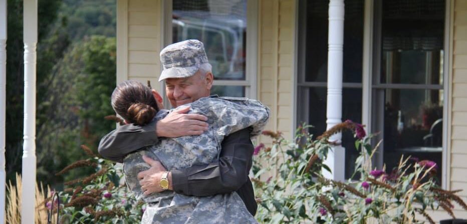 Actors portraying a daughter dressed in army gear reuniting with her father.