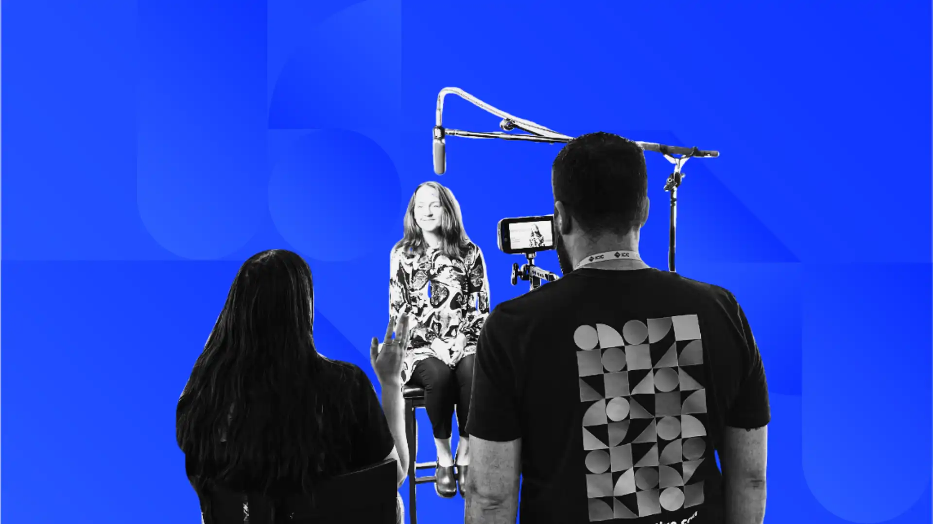 A videographer and a producer interviewing  someone with a camera and microphone.